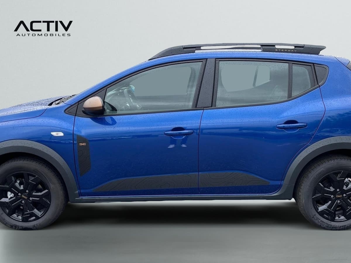 Dacia Sandero Gpl : profil gauche bleu avec barres de toit, jantes noires et bas de caisse sombre