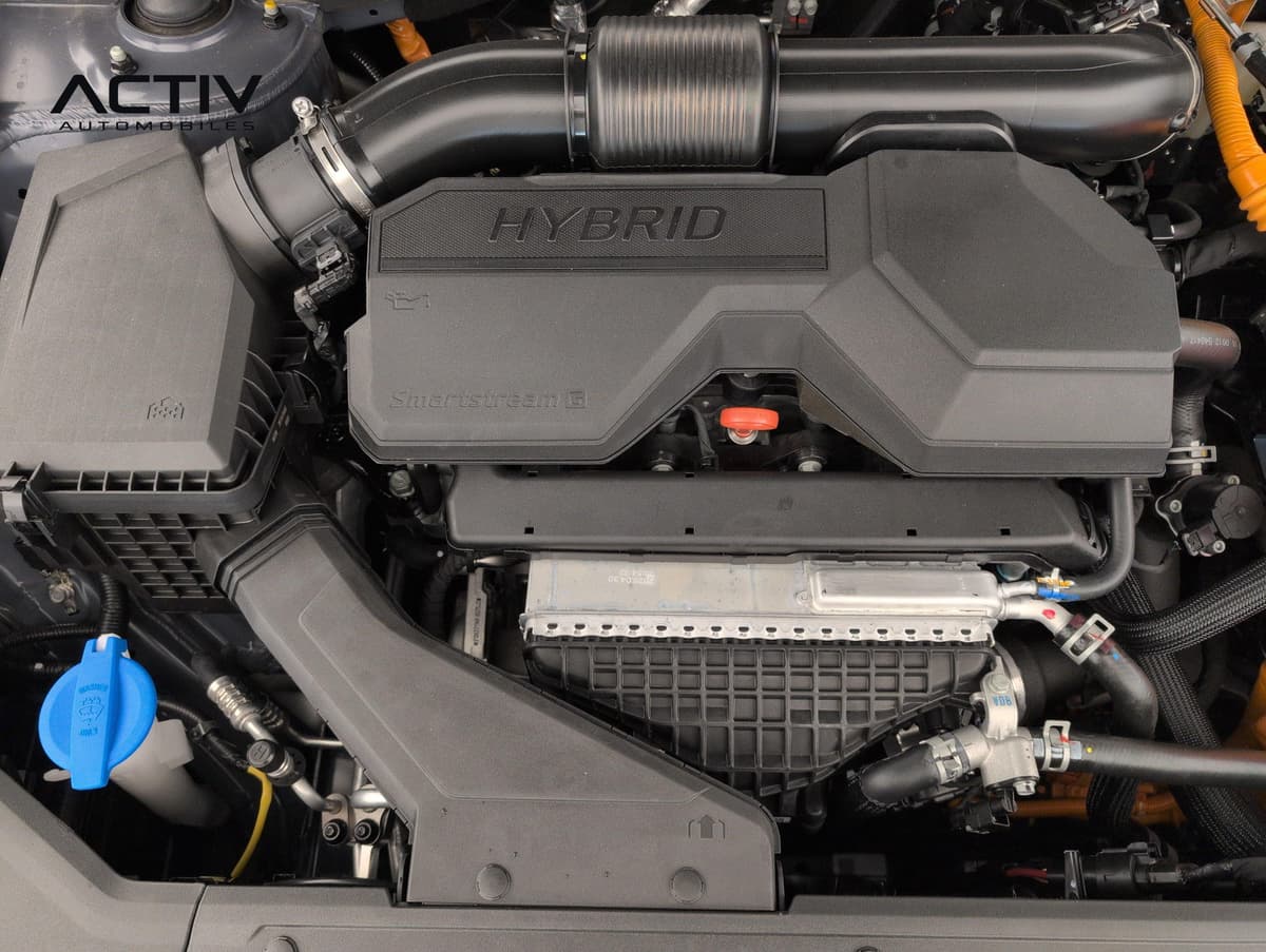 Hyundai Tucson : compartiment moteur hybride avec cache moteur noir et bouchon de lave-glace bleu