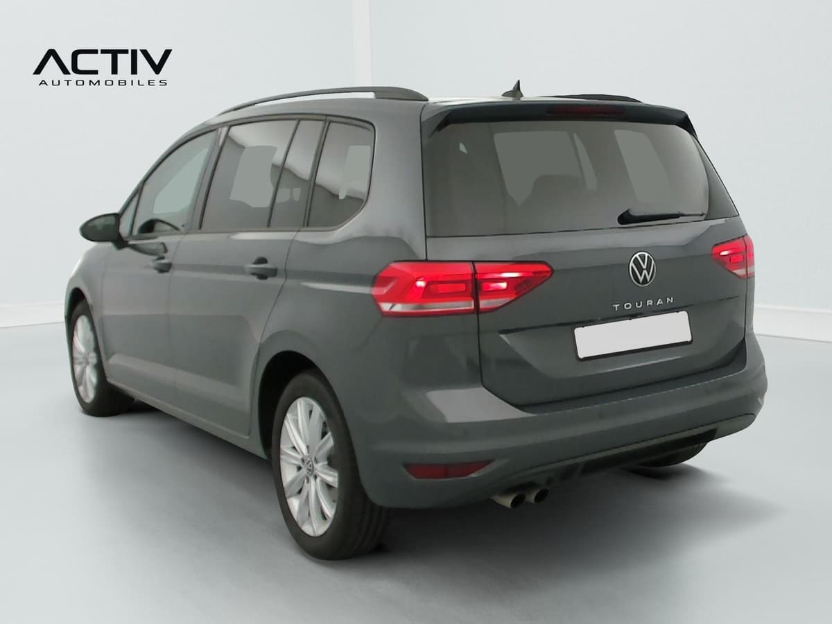 Volkswagen Touran : arrière trois quarts gauche, monospace gris avec rampe de pavillon et jantes alliage