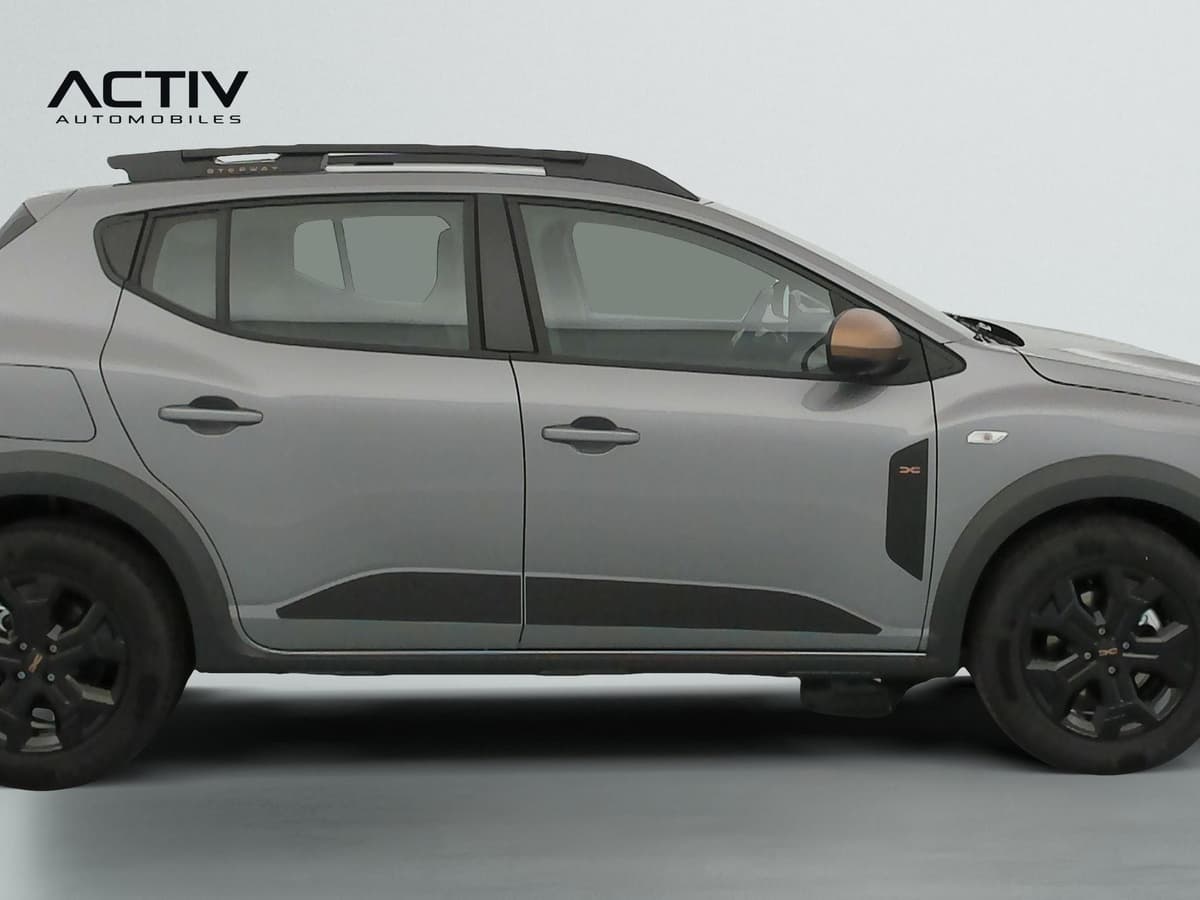Dacia Sandero Gpl : profil droit gris avec barres de toit noires et jantes alliage sombres