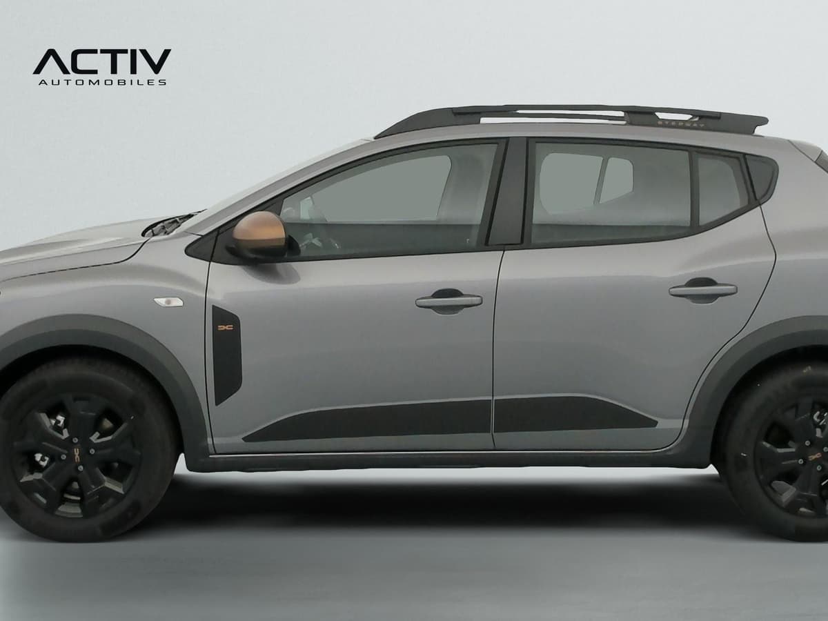 Dacia Sandero Gpl : profil gauche avec barres de toit, jantes noires et bas de caisse noirs