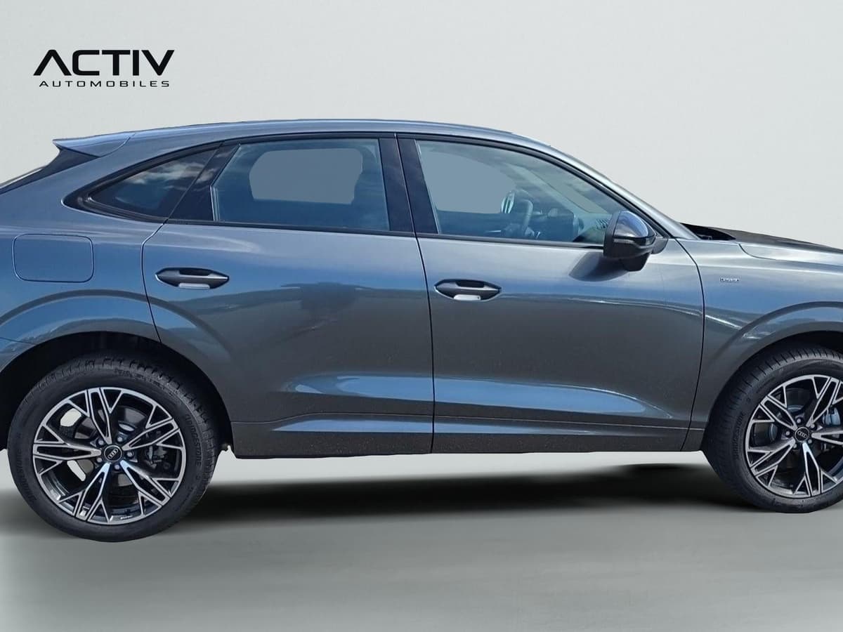 Audi Q3 Sportback Hybride : profil droit d'un SUV coupé gris avec jantes bicolores et trappe de recharge