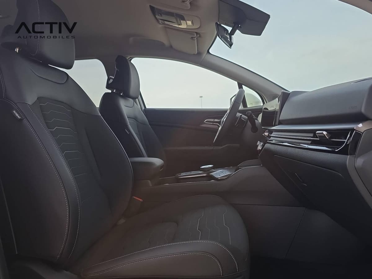 Kia Sportage : sièges avant noirs et poste de conduite vus depuis la place passager