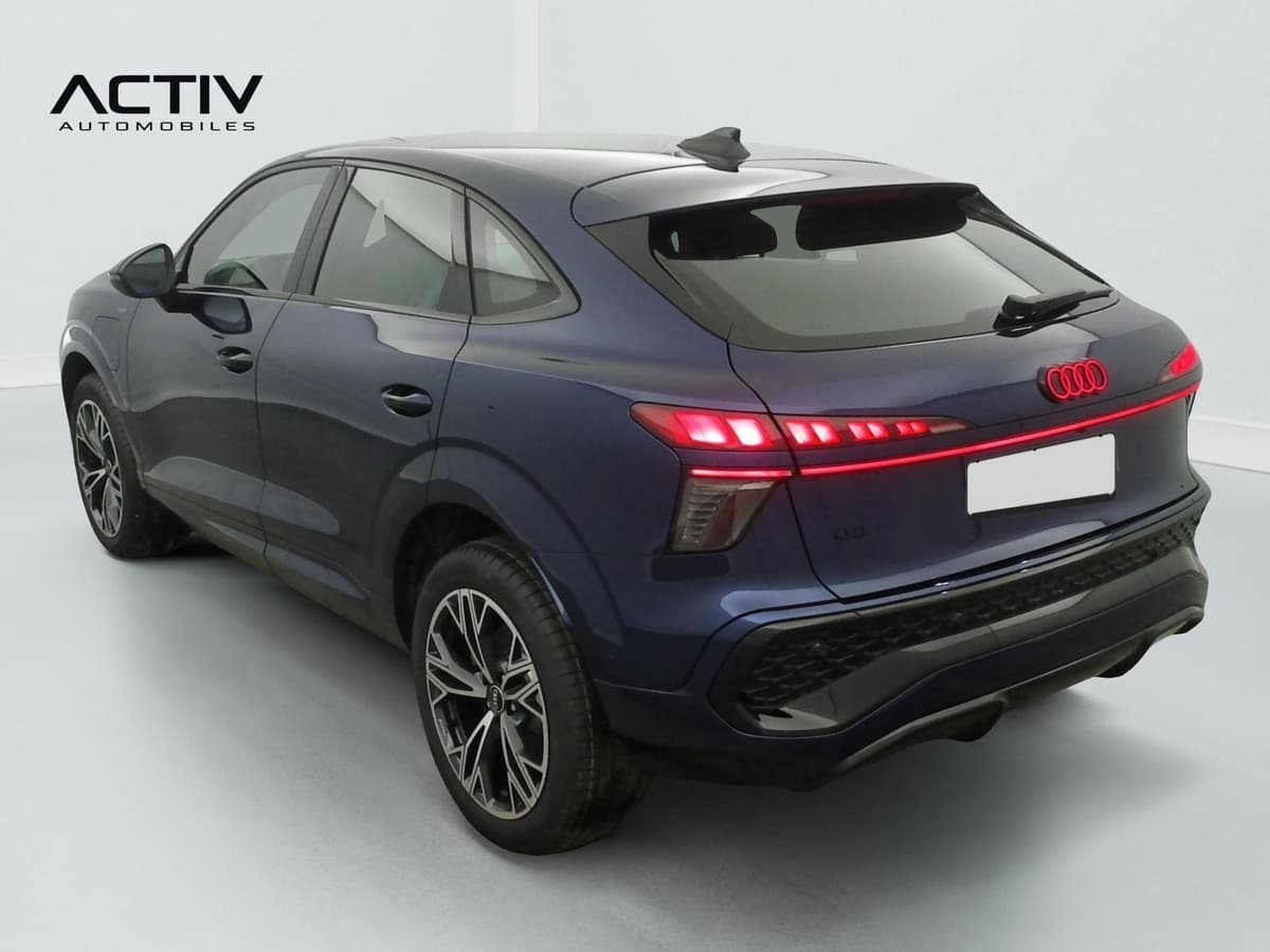 Audi Q3 Sportback Hybride : arrière trois quarts gauche avec feux à LED allumés et jantes bicolores