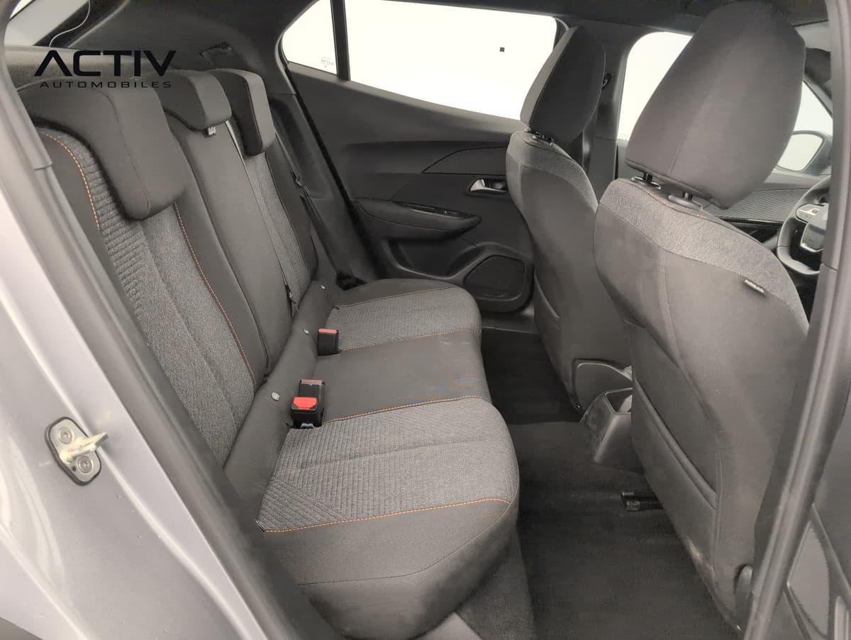 Peugeot 2008 : banquette arrière en tissu sombre à surpiqûres orange, vue par la portière ouverte