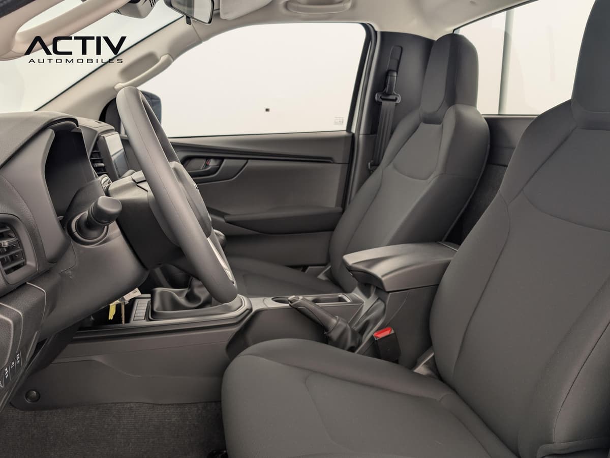 Isuzu D-MAX : habitacle avant avec sièges en tissu sombre, volant et levier de vitesses manuel