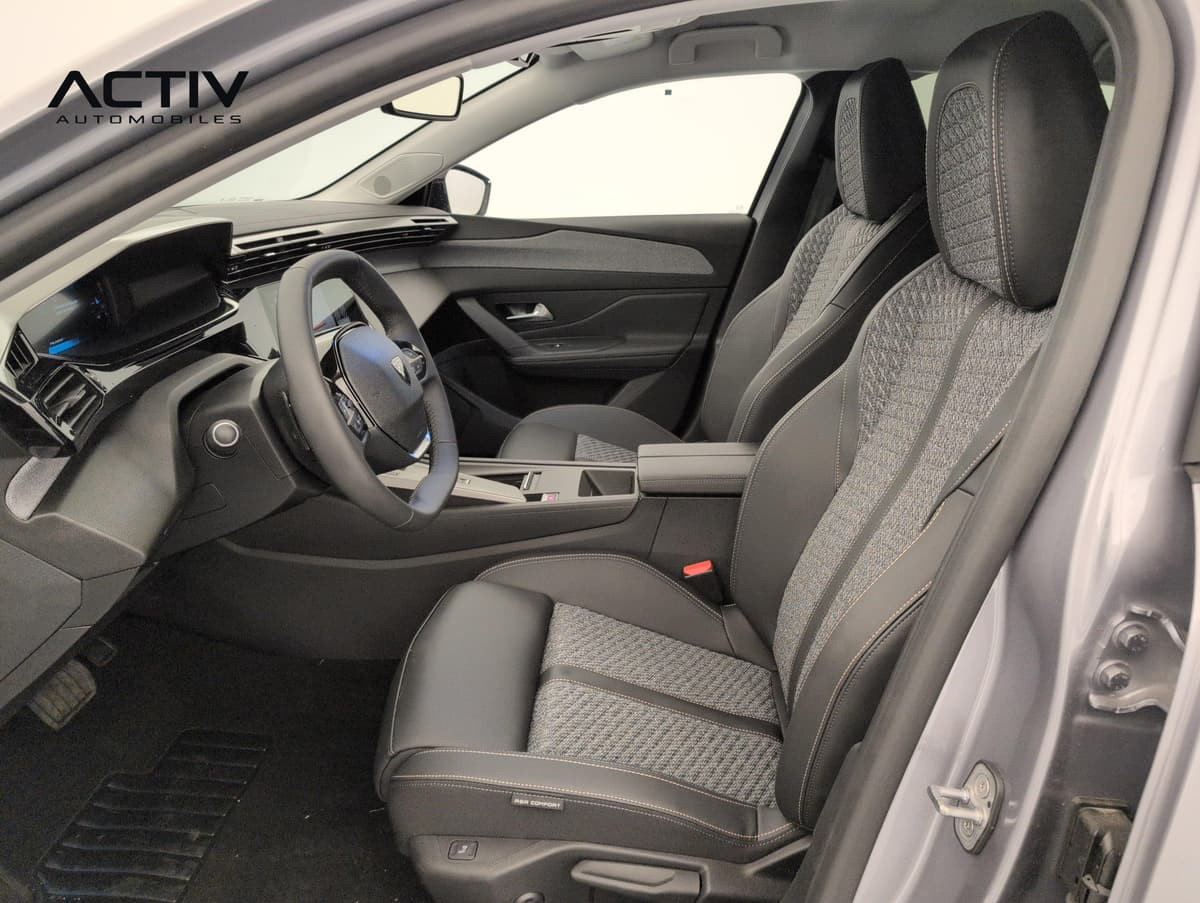 Peugeot 308 Nouvelle : sièges avant en tissu gris et matière noire avec surpiqûres, vus par la portière