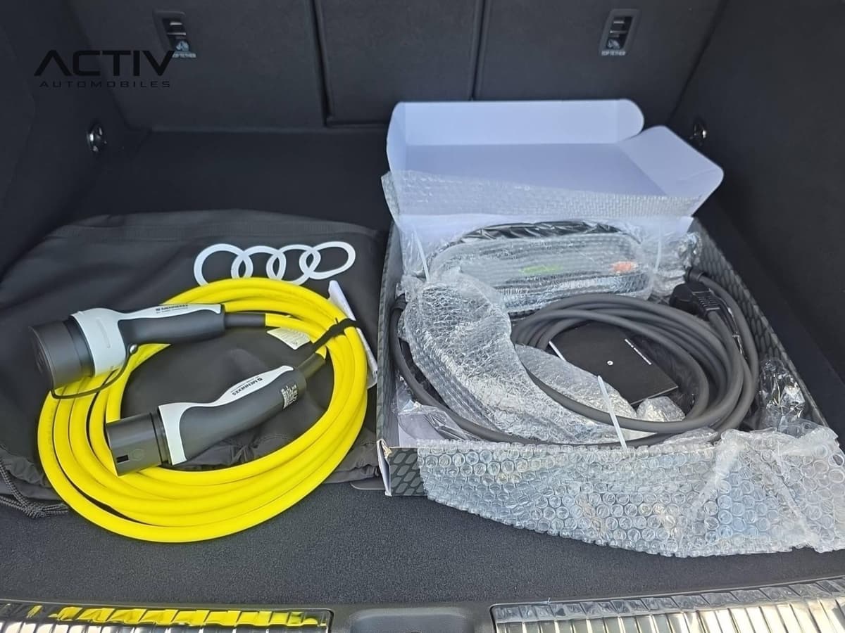 Audi Q3 Sportback Hybride : coffre ouvert avec câbles de recharge jaune et gris rangés dans leur emballage