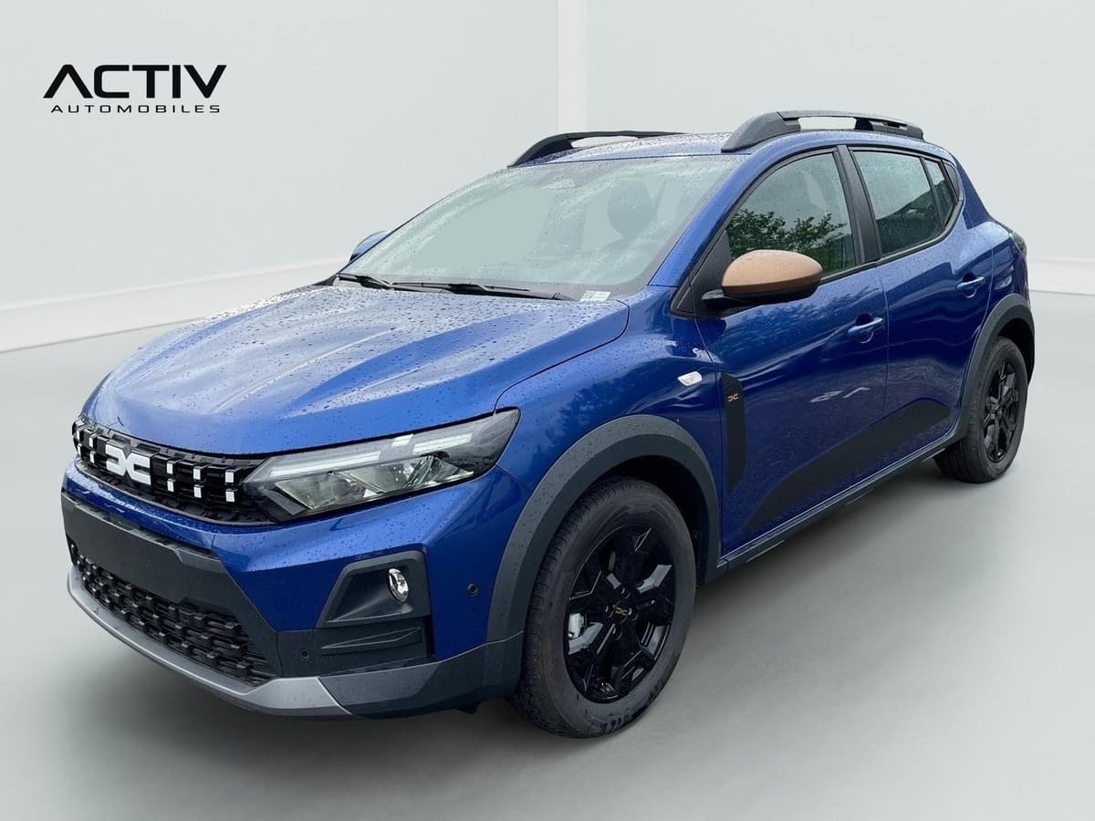 Dacia Sandero Gpl : avant trois quarts gauche, bleu, barres de toit, jantes noires et rétroviseur cuivré