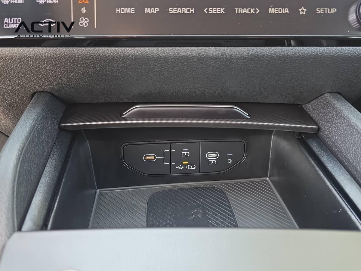 Kia Sportage : compartiment avec ports USB et zone de chargement du téléphone par induction