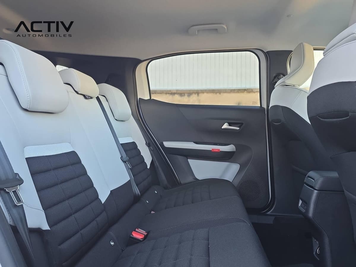 Citroën C3 Aircross : banquette arrière en tissu noir et gris clair, vue par la portière ouverte