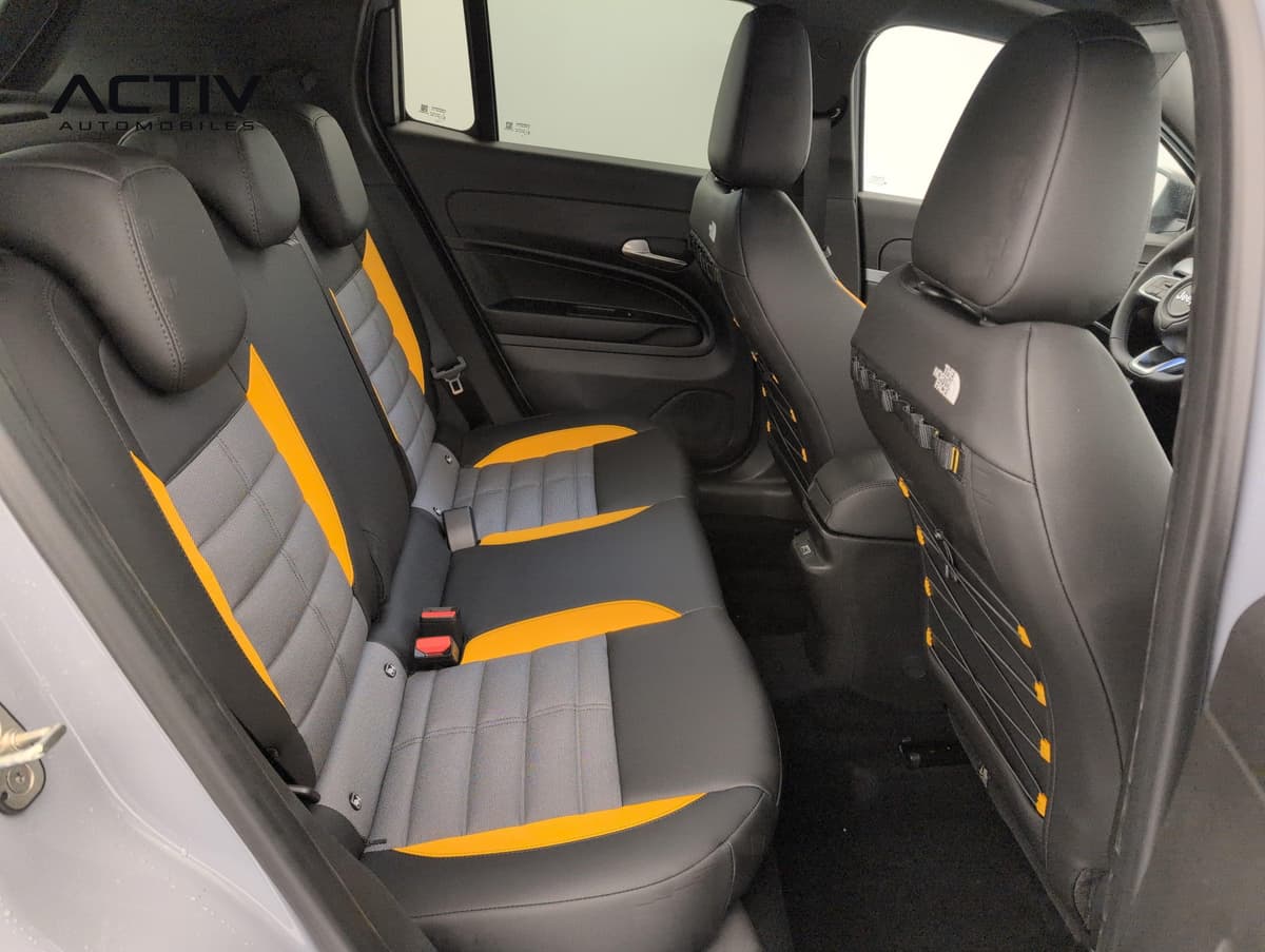 Jeep Avenger : banquette arrière noire, grise et jaune vue par la portière avant ouverte