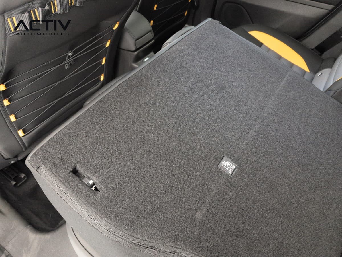 Jeep Avenger : dossier de banquette arrière rabattu, face moquettée grise, sangles élastiques jaunes
