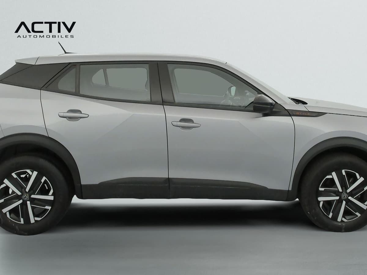Peugeot 2008 : profil droit du SUV gris avec jantes bicolores et protections de bas de caisse noires