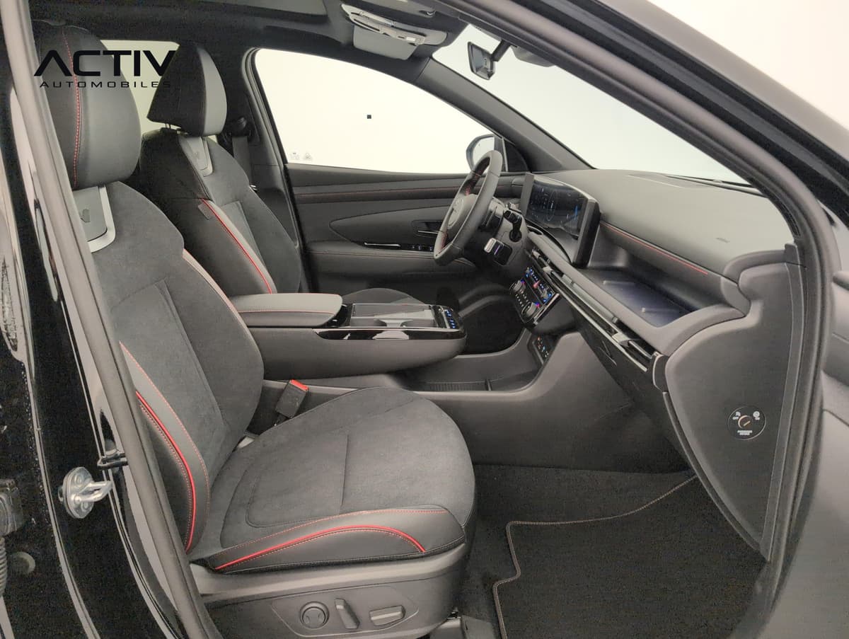 Hyundai Tucson : sièges avant en alcantara noir à surpiqûres rouges, vus par la portière passager