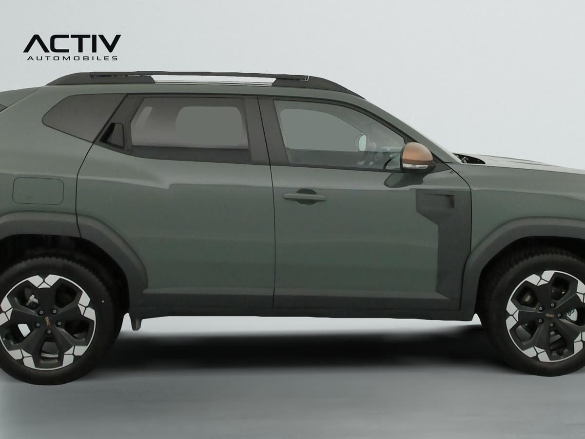 Dacia Duster : profil droit du SUV kaki avec barres de toit, jantes bicolores et rétroviseur cuivré