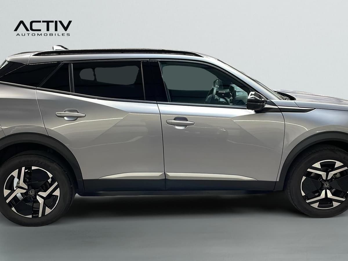 Peugeot 2008 : profil droit du SUV gris avec jantes alliage bicolores et barres de toit
