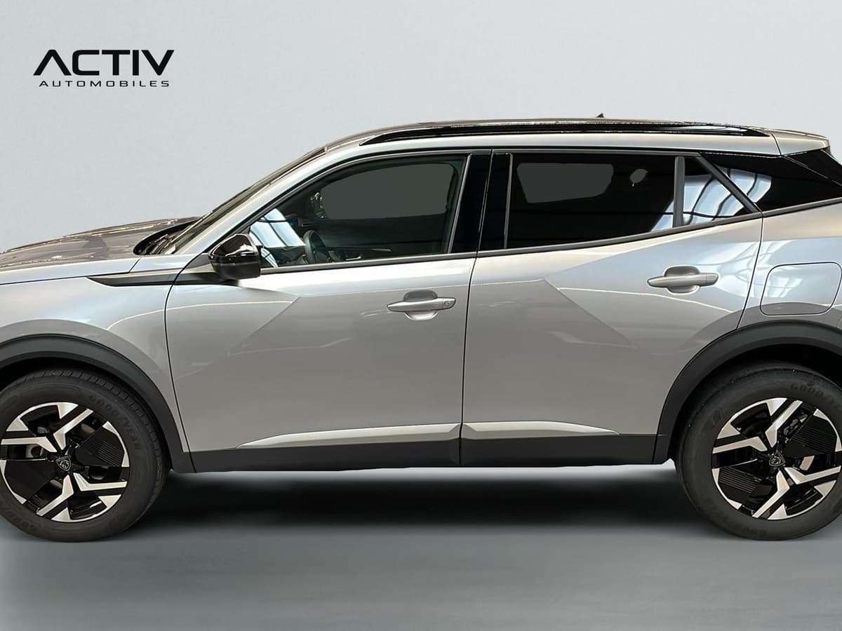 Peugeot 2008 : profil gauche du SUV gris clair avec jantes alliage bicolores et barres de toit