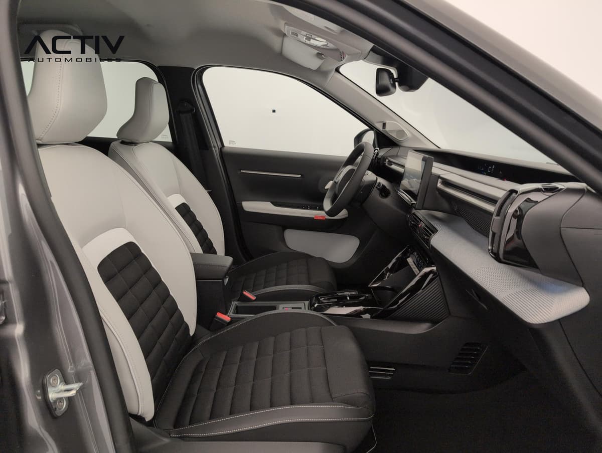 Citroën C3 Aircross : sièges avant bicolores noir et gris clair vus depuis la portière passager ouverte