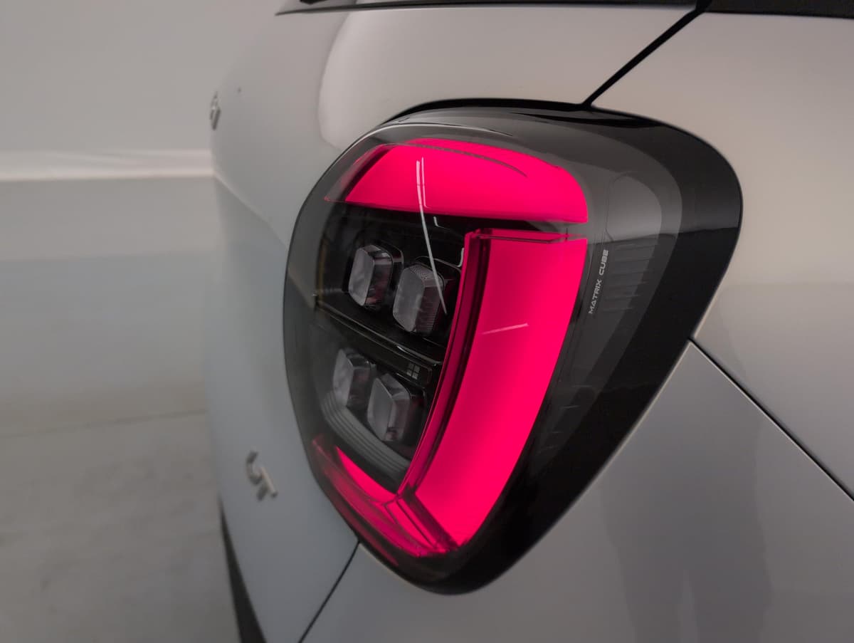Aion UT : feu arrière allumé en rouge-rose avec éléments lumineux en bandes