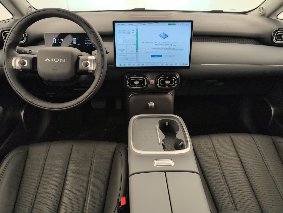 Aion UT : planche de bord avec grand écran tactile, volant et console centrale avec porte-gobelets