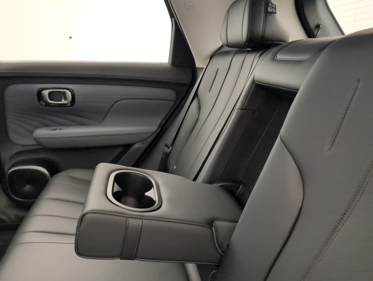 Aion UT : accoudoir central arrière rabaissé avec porte-gobelets, banquette noire
