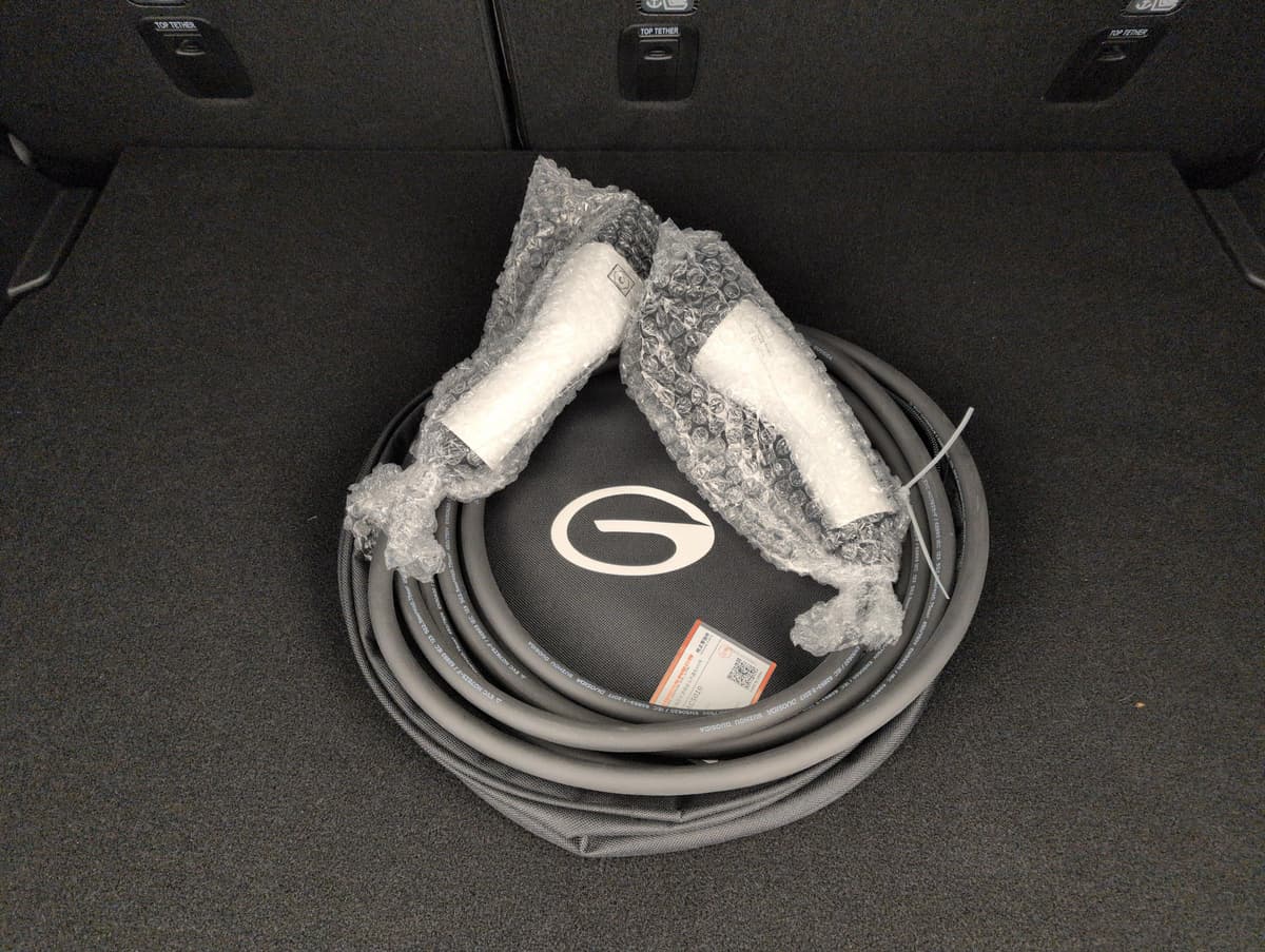 Aion V : câble de recharge enroulé dans son sac, posé dans le coffre