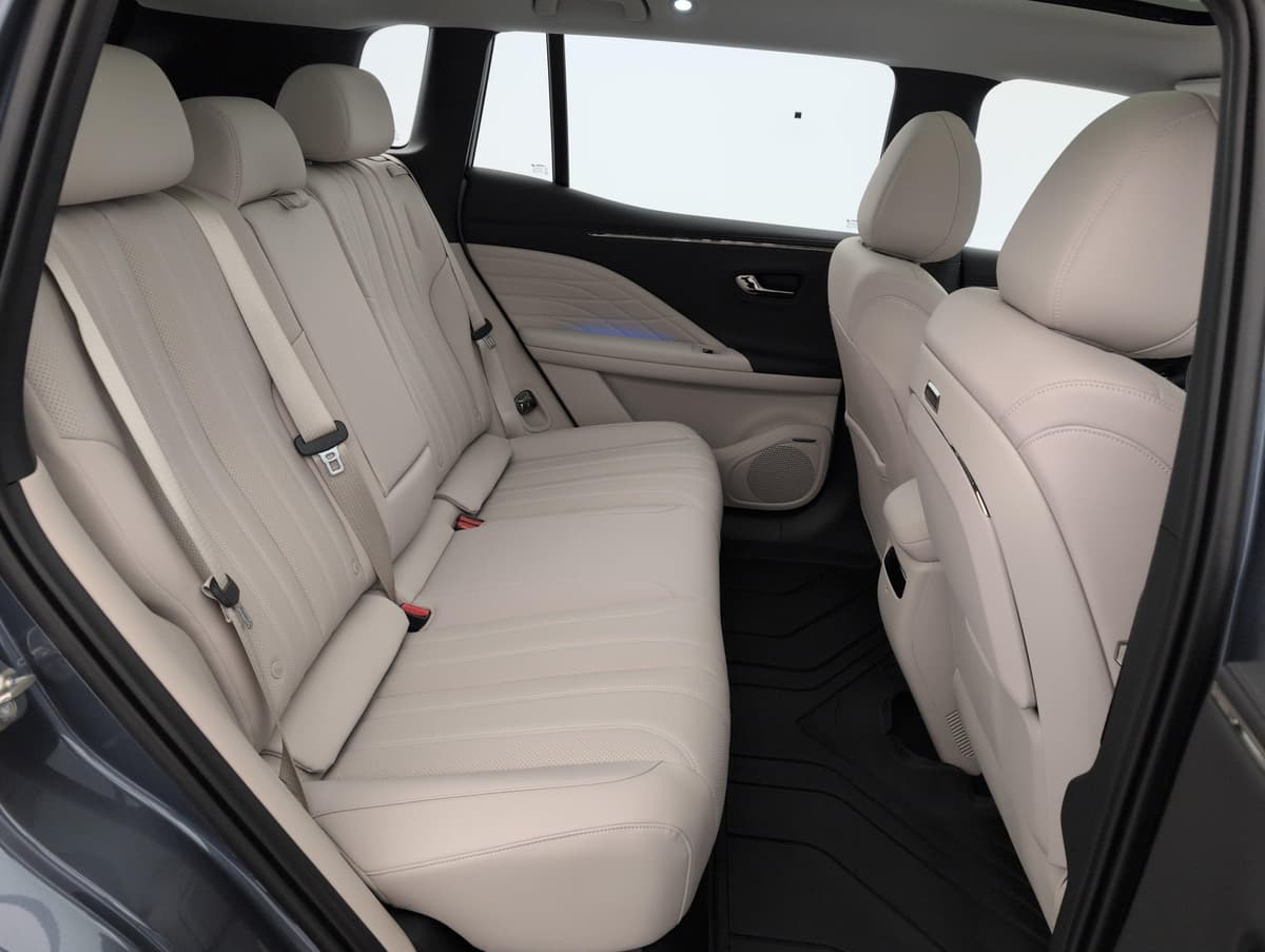 Aion V : banquette arrière beige vue par la portière arrière ouverte, tapis de sol en caoutchouc