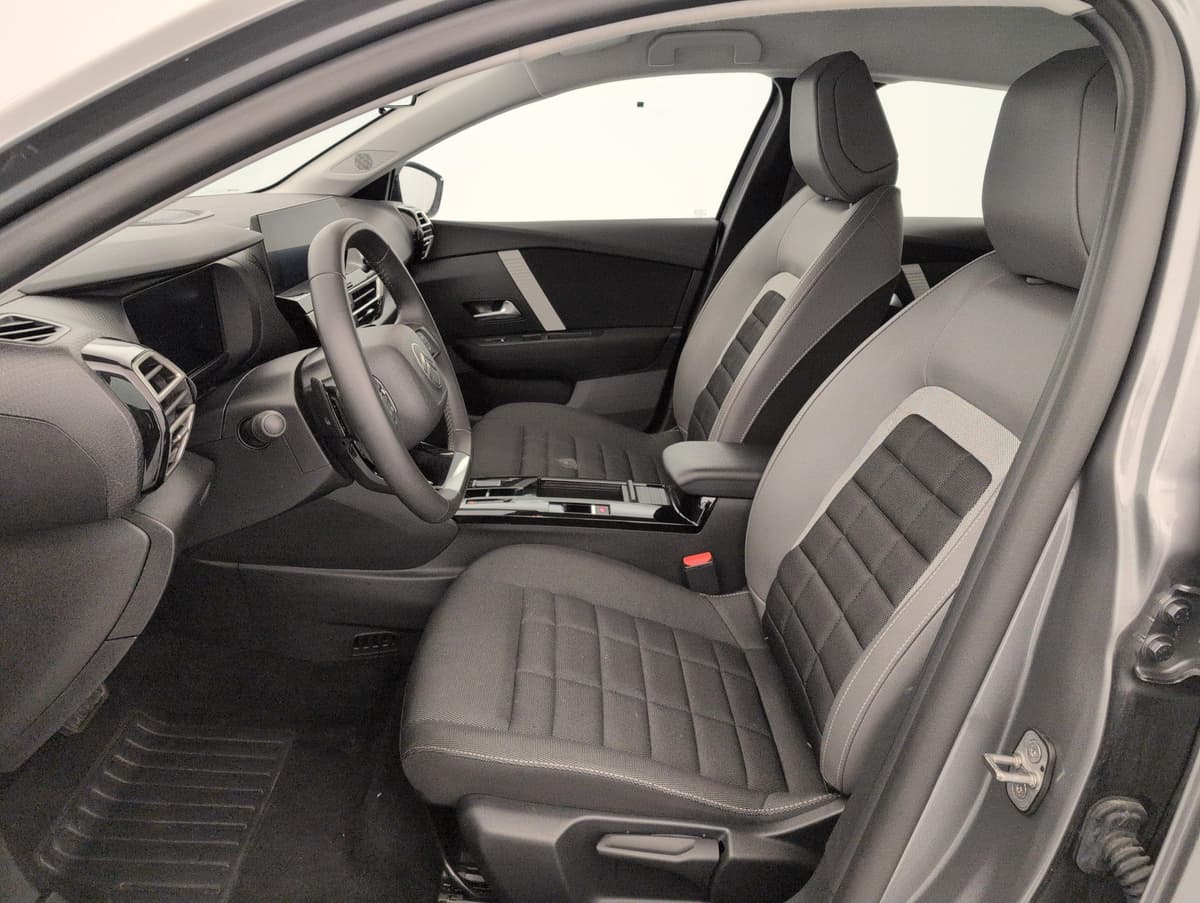 Citroën C4 : sièges avant en tissu gris et noir vus par la portière conducteur ouverte