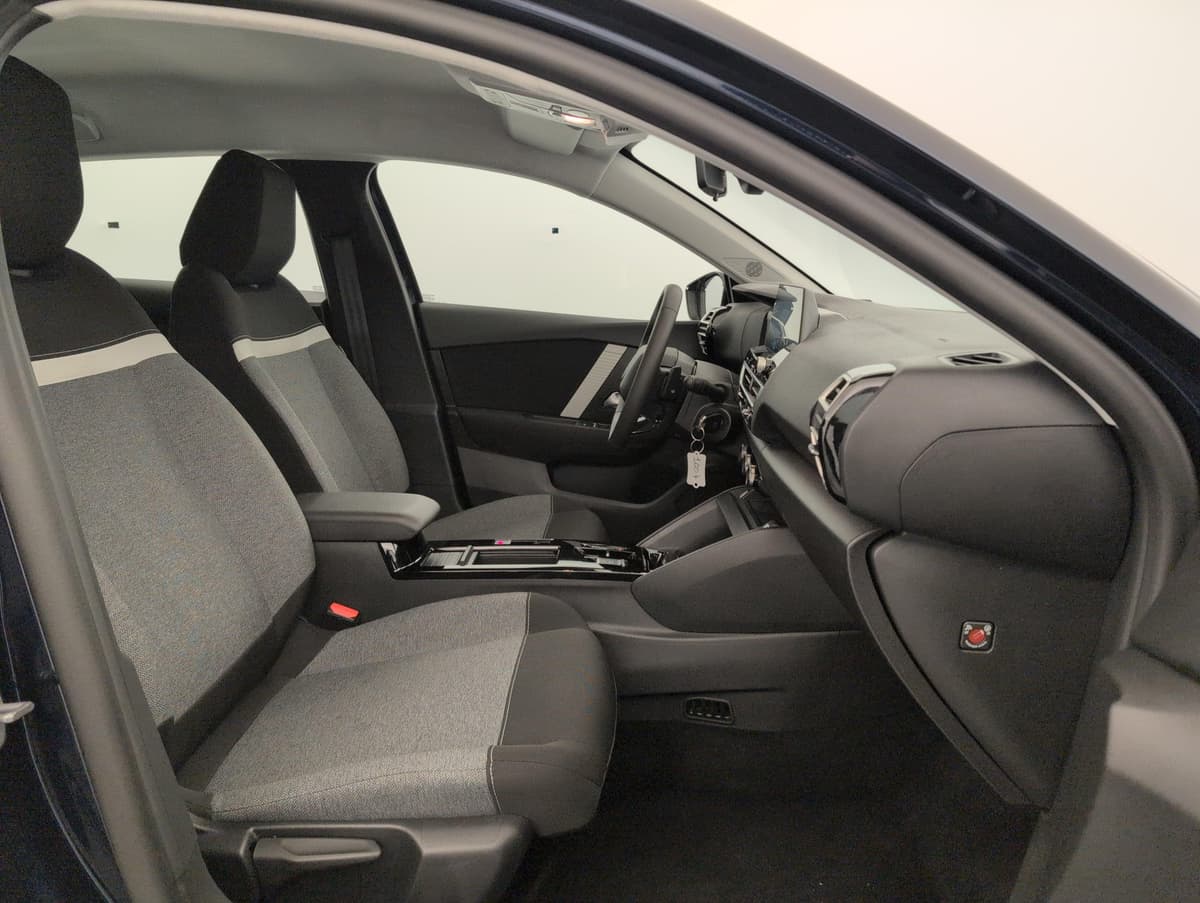 Citroën C4 : sièges avant en tissu gris et noir vus depuis la portière passager ouverte