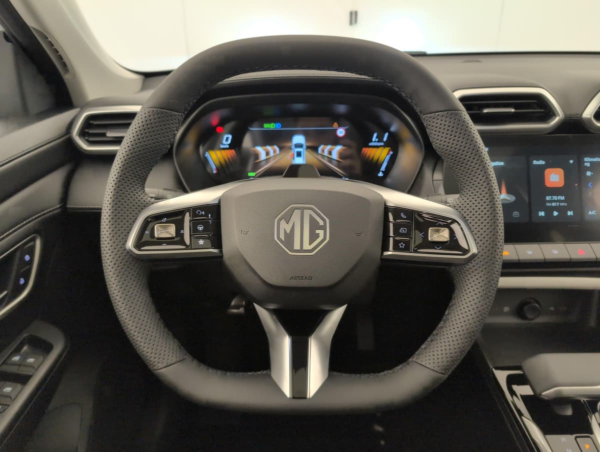 Mg ZS : volant perforé noir avec commandes au volant et combiné numérique derrière