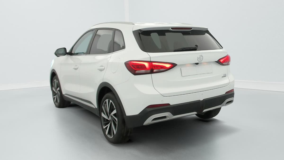 Mg ZS : vue arrière trois quarts gauche d'un SUV blanc aux feux allumés
