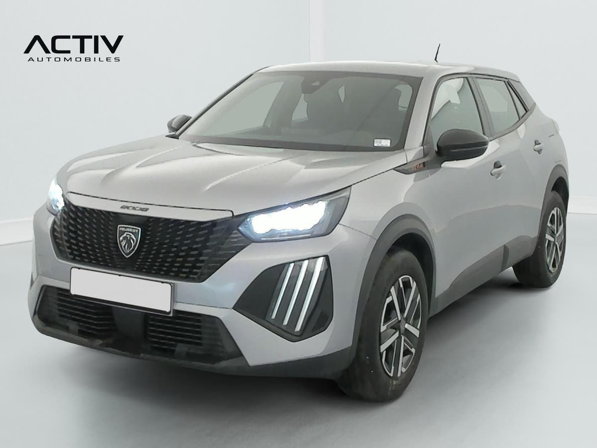 Peugeot 2008 : avant trois quarts gauche d'un SUV gris avec projecteurs LED allumés