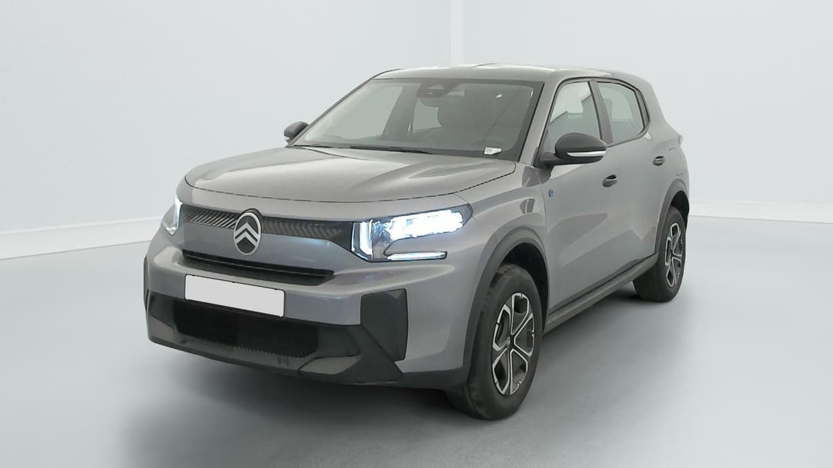 Citroën E-C3 Aircross : SUV gris vu de l'avant côté gauche, projecteurs allumés et enjoliveurs bicolores