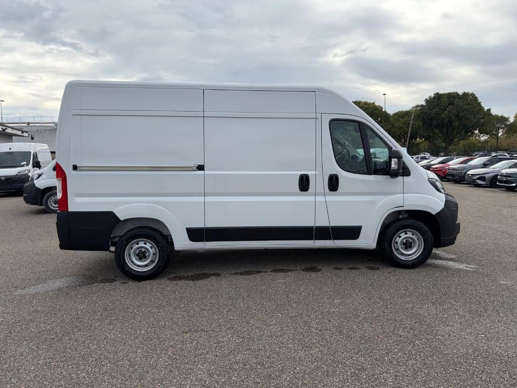 Peugeot Boxer Fourgon : profil droit du fourgon blanc avec porte latérale coulissante tôlée